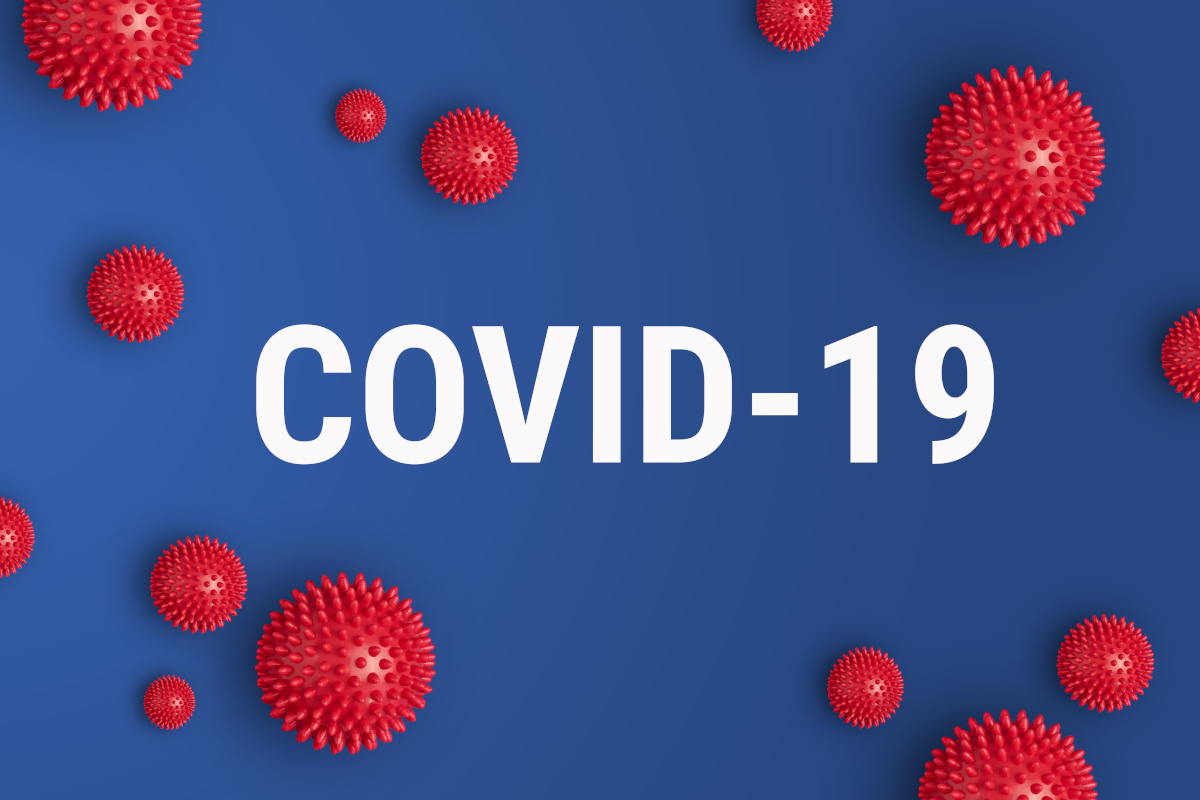 The word COVID-19 over a blue background with red 3d models floating around it to represent the virus