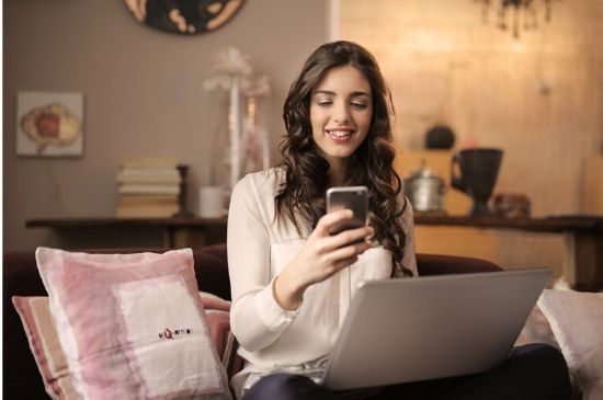 Smiling Young Woman Working From Couch